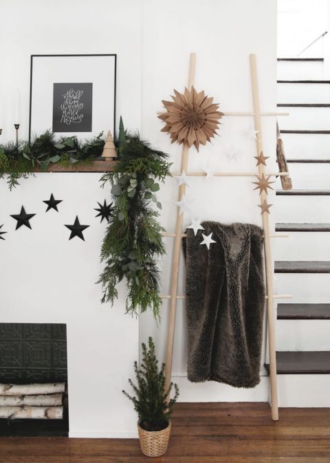 fireplace with blanket ladder next to it with 3D star decorations