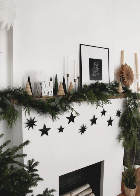 mantel with christmas decorations and black star garland