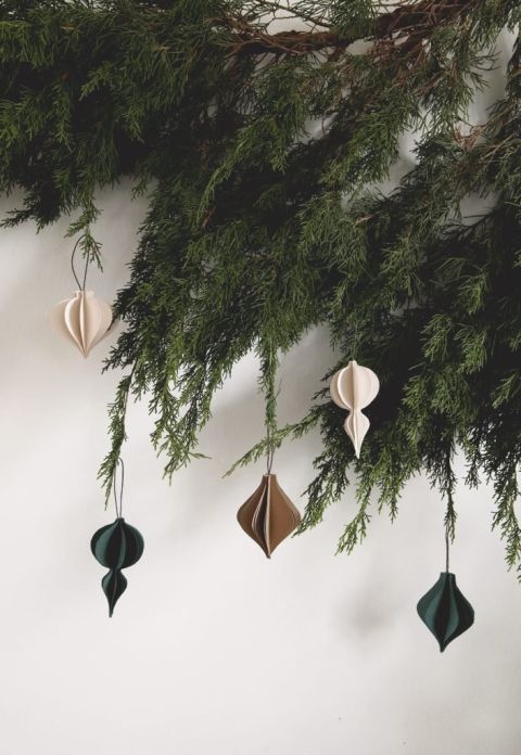 greenery with 3D paper ornaments hanging from it
