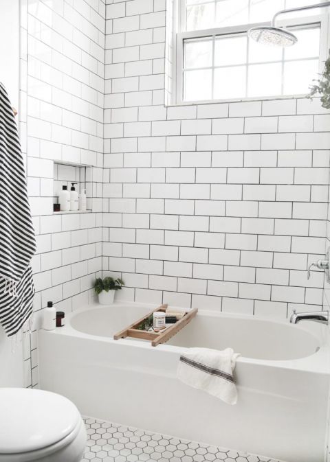 tiled black and white bathroom with wood bath tray