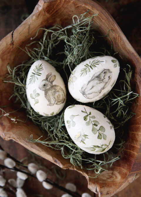 bunny and greenery easter eggs on green moss in wood bowl
