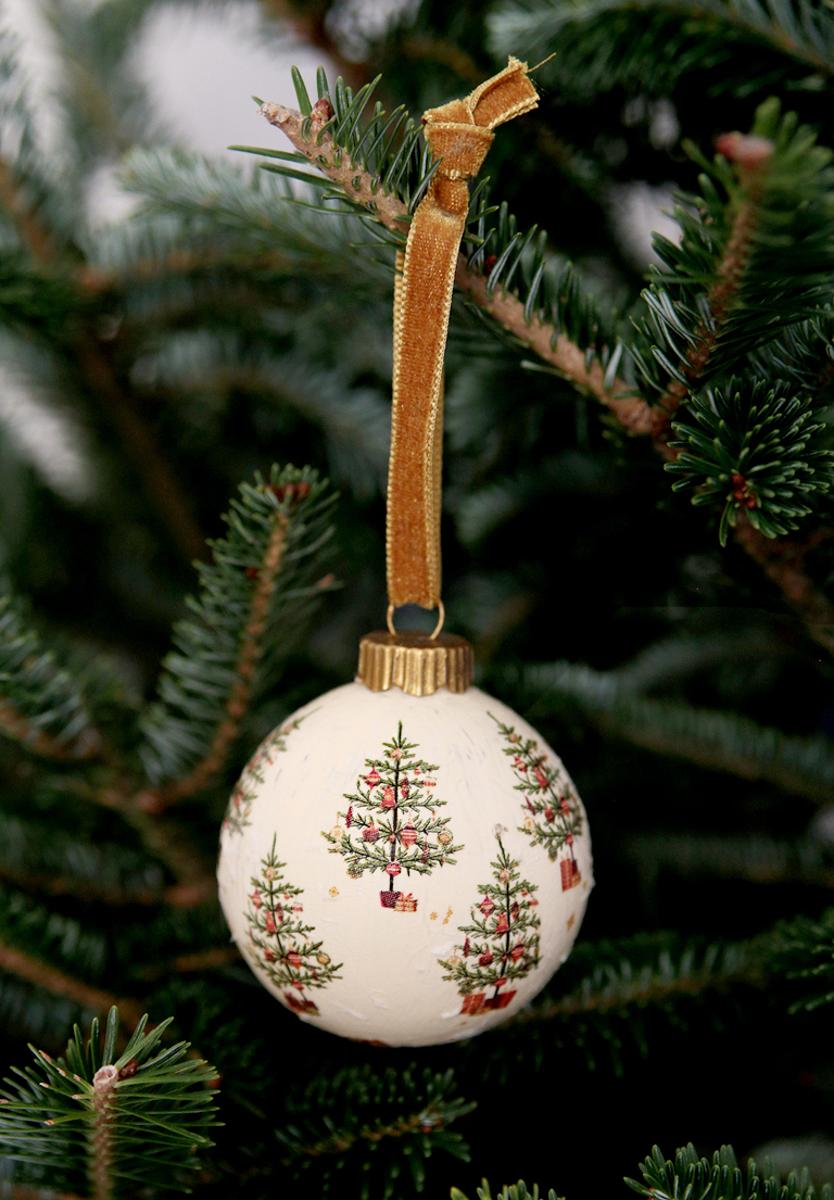 vintage christmas tree decoupage ornament with gold ribbon hanging from branch