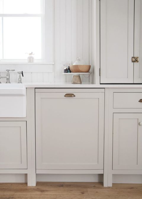 panel dishwasher with beige shaker style panel and brass handle