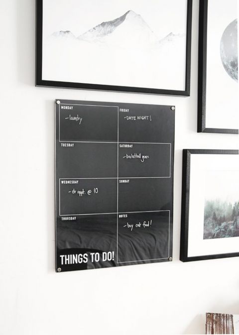 black dry erase wall calendar hanging on white wall
