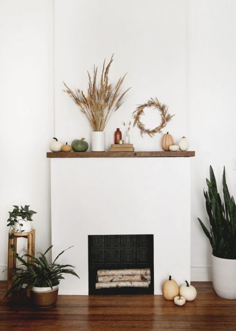 fireplace mantel with pumpkins and dried grass decor