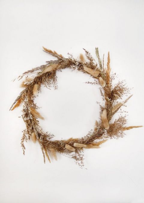 dried grass fall wreath hanging on white wall