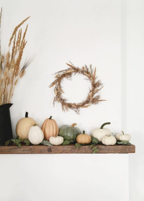 wood mantel with pumpkins and dried grass wreath