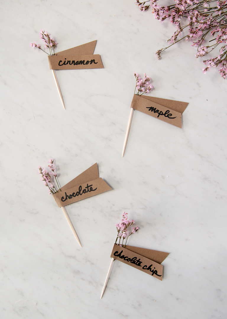 fresh flower toothpick food labels laying on marble board with flowers next to labels
