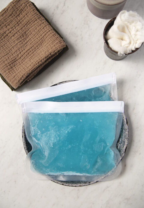 blue homemade diy gel ice packs sitting in metal tin with cloths around it