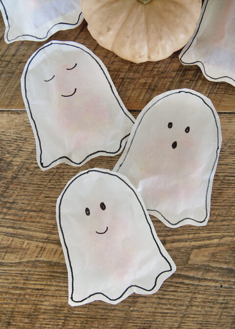 paper ghost treat bags laying on wood table