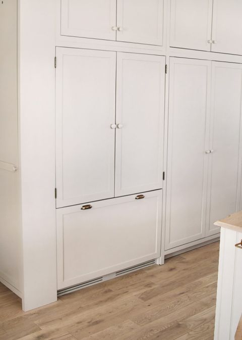 wall of beige kitchen cabinets with integrated refrigerator