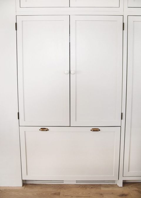 beige integrated panel refrigerator with wood knobs and brass handles