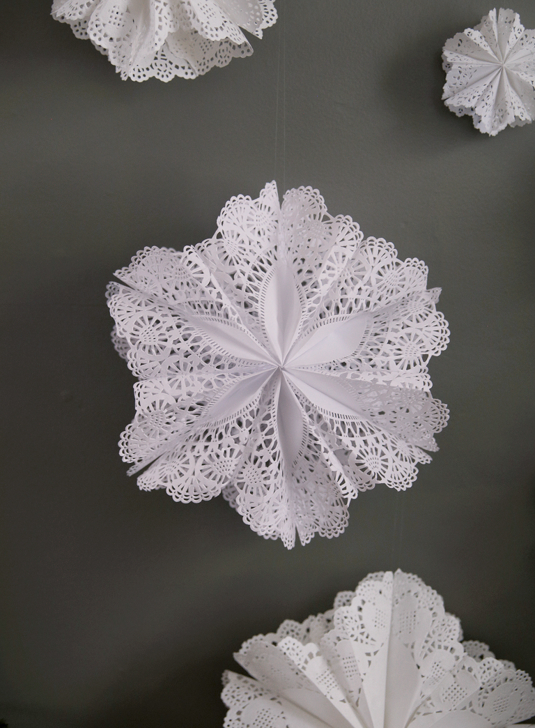 diy paper doily snowflake on green wall