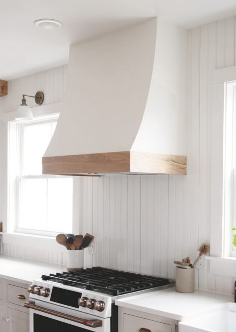 white and wood curved range hood cover over stove