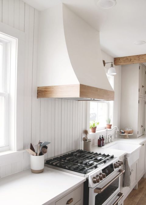 curved white and wood range hood cover over white range