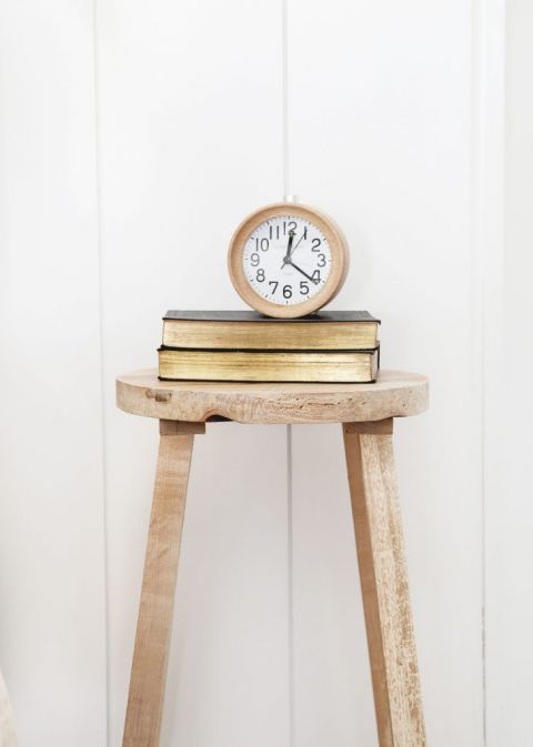 wood stool with 2 books on it and round wood clock