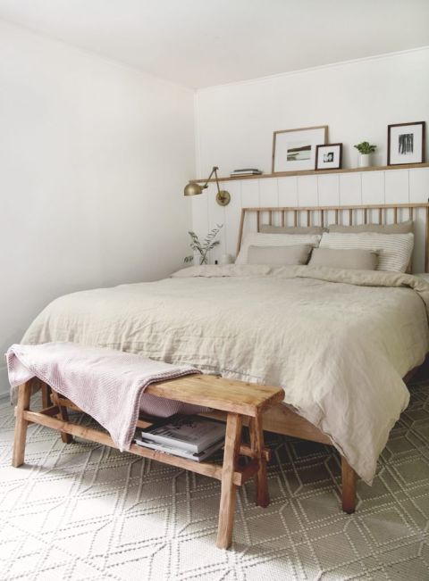 bedroom with taupe linen cover and skinny bench at end of bed