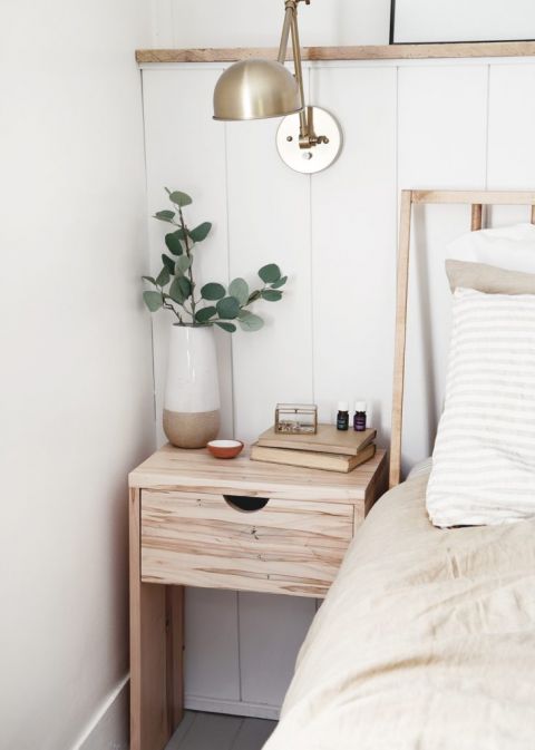 bedroom with eucalyptus on nightstand with brass lamp