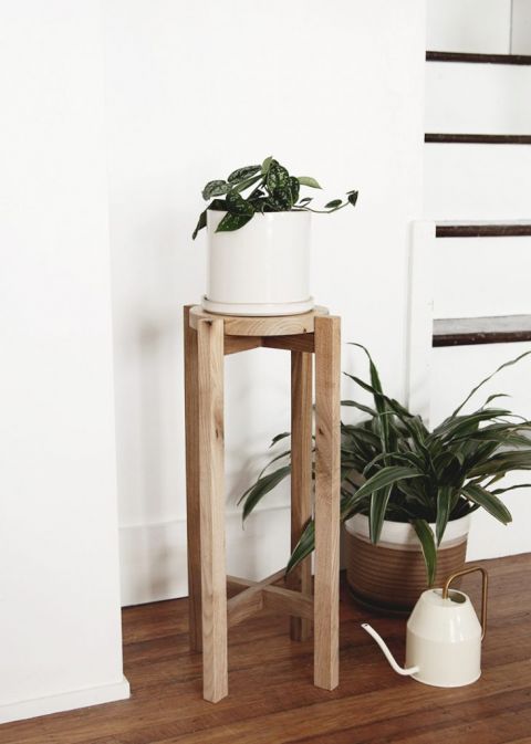 diy wood plant stand with plant on it next to watering can