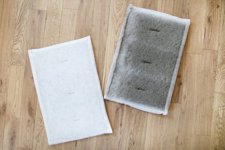 two furnace air filters, white clean one next to dirty used one