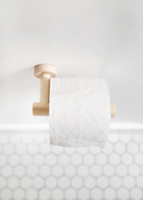 dowel toilet paper holder with tile floor in background
