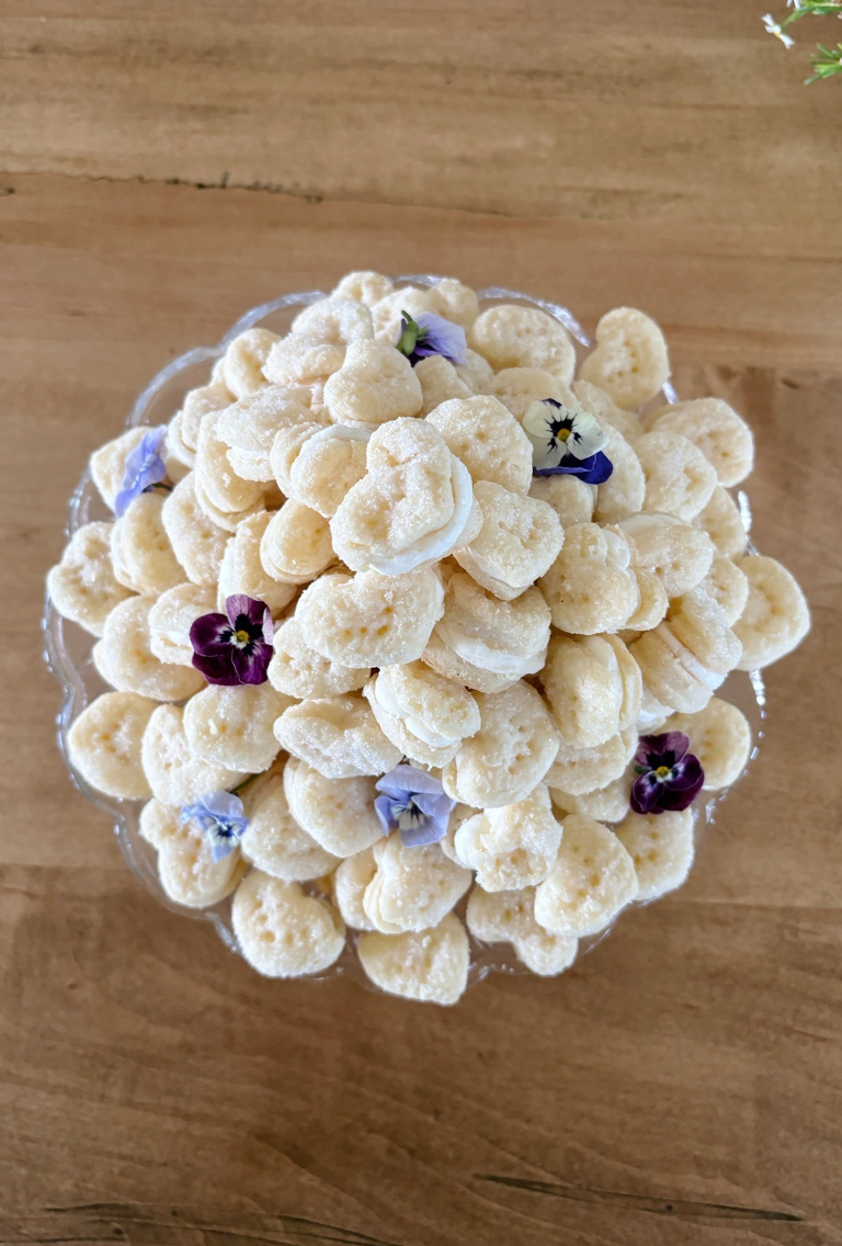 platter of sugar cream wafer cookies with edible flowers on cookies