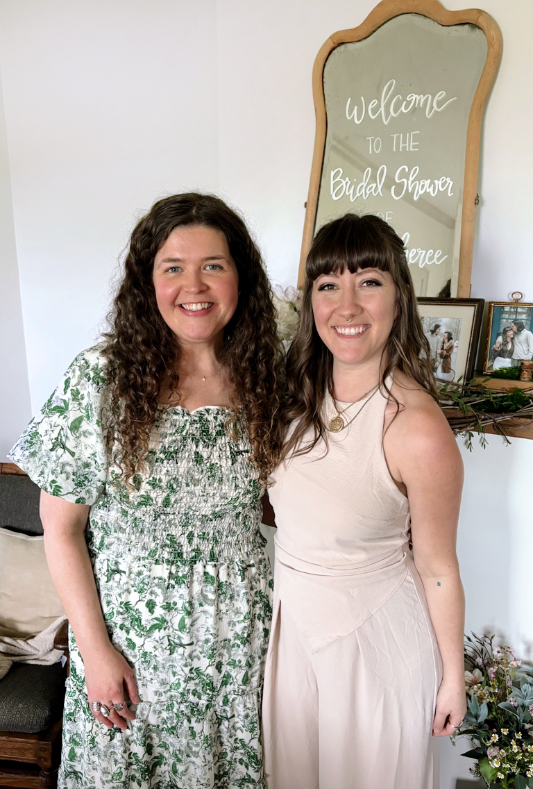 two woman posing at floral bridal shower