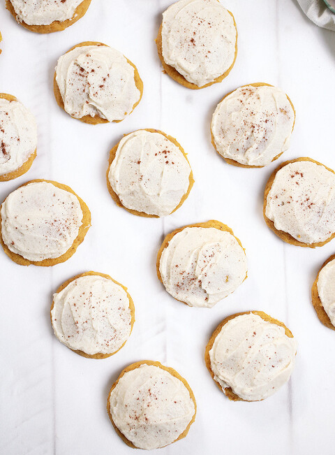 rows of soft pumpkin cookies with brown sugar frosting on white background
