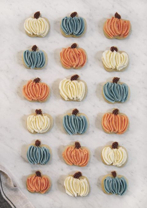 frosted orange, blue and white pumpkin sugar cookies on counter