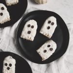 black plate with white ghost treats on them