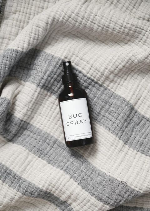 spray bottle of homemade bug spray on gray blanket