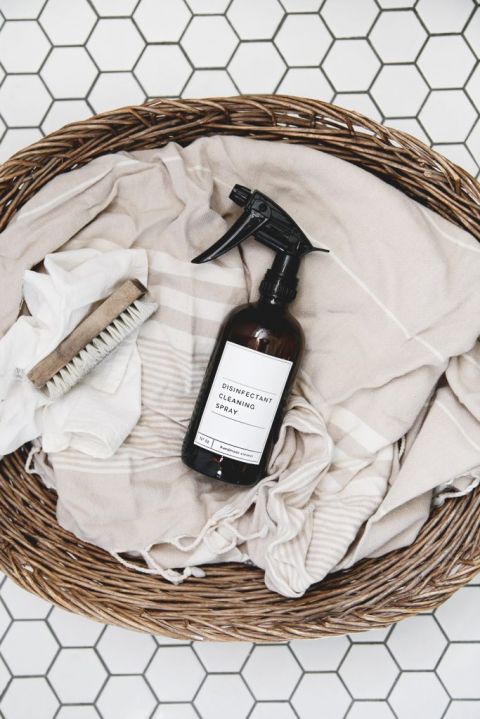 homemade disinfectant spray laying on towel in basket