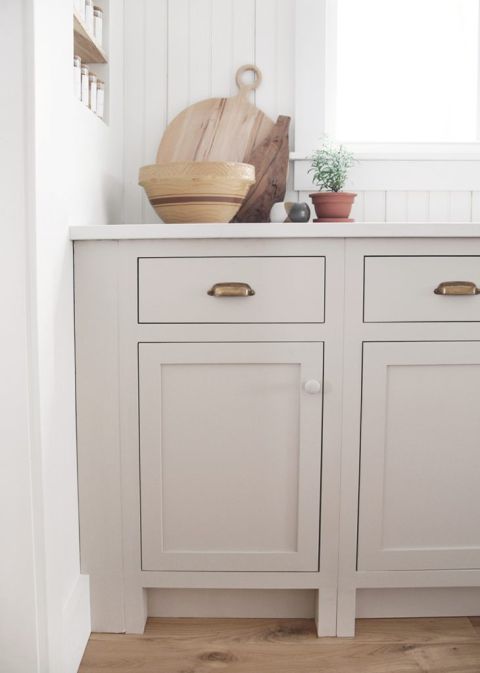 beige kitchen cabinet with aged brass