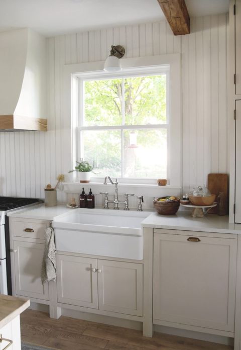 farmhouse kitchen with large white sink and beadboard wall