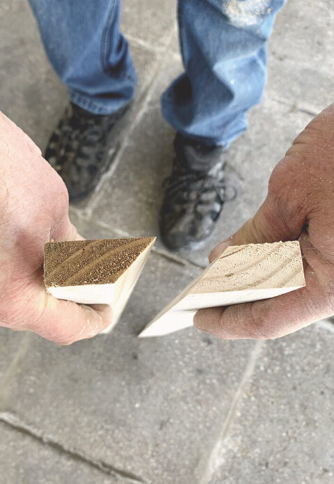 person holding two pieces of wood cut at a 45 degree angle