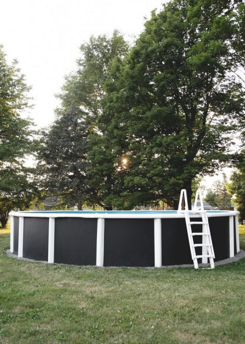 pool with painted black walls in yard with green trees