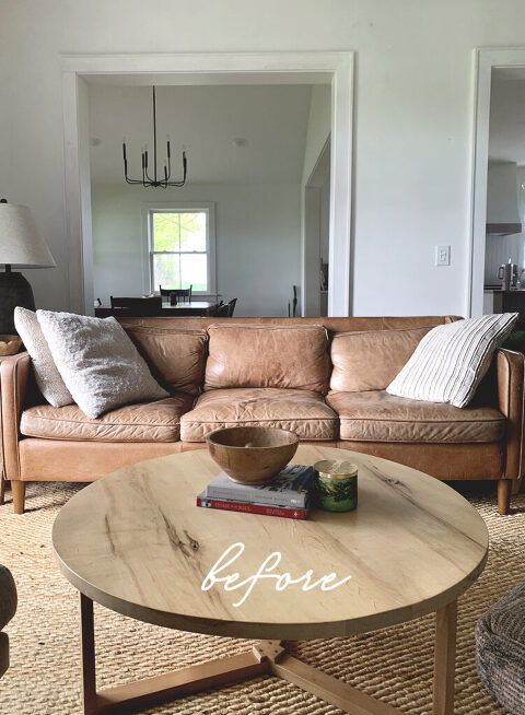 living room with old leather couch and round wood coffee table