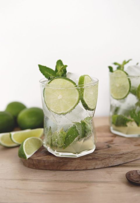 clear glass of mojito mocktail with limes and mint in it