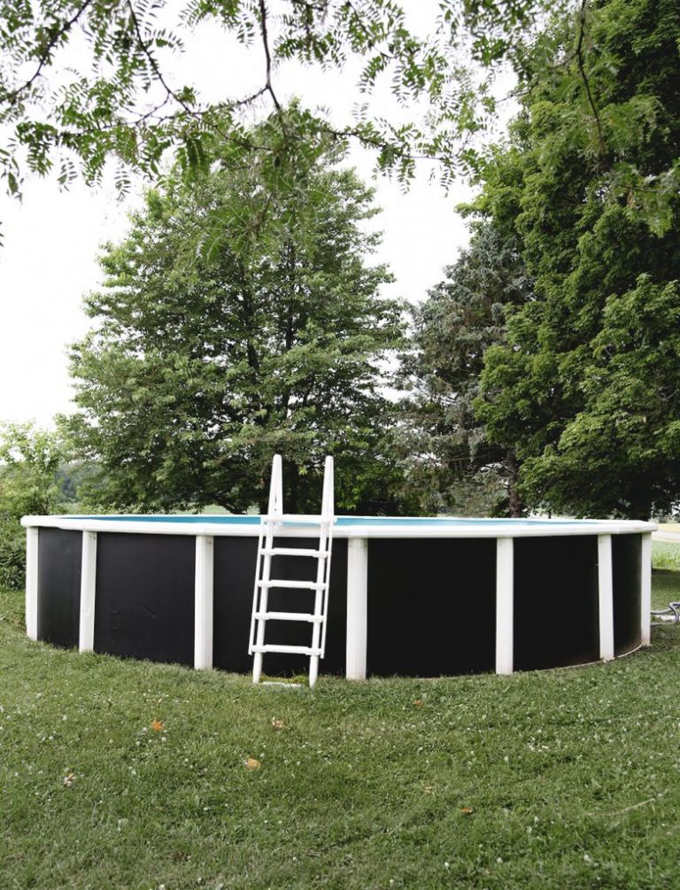 above ground pool with painted black walls with white ladder