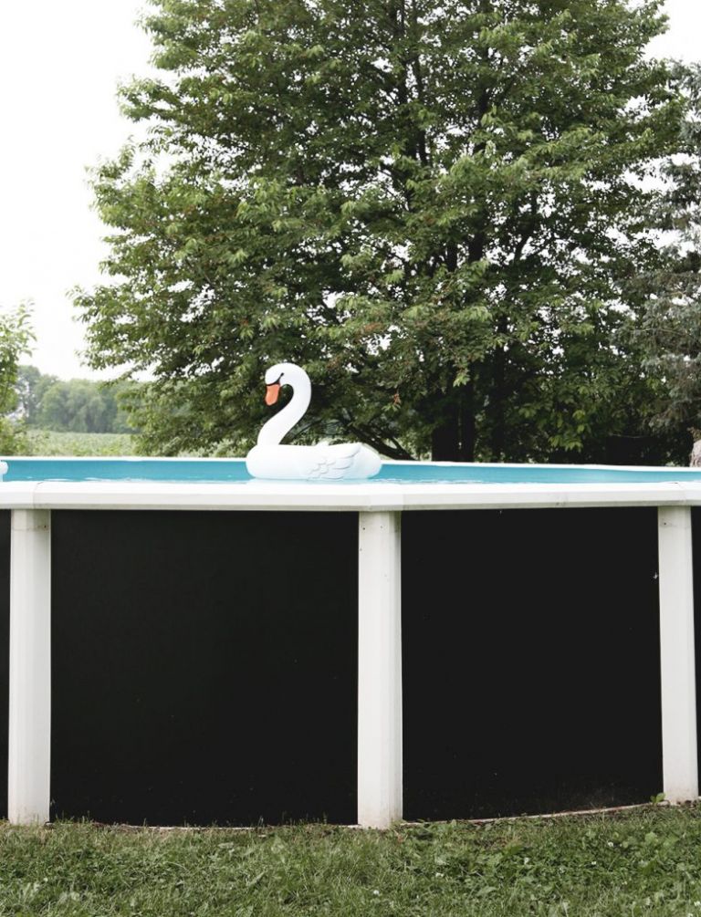 above ground pool with black walls and swan float in it