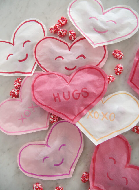 pink paper heart treat bag that says hugs on it sitting on more heart treat bags