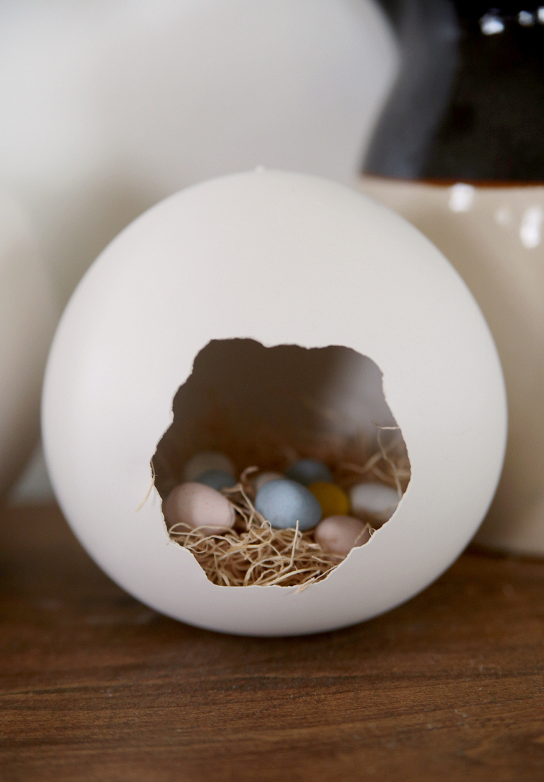 giant plaster easter egg filled with easter grass and cadbury mini eggs sitting on table