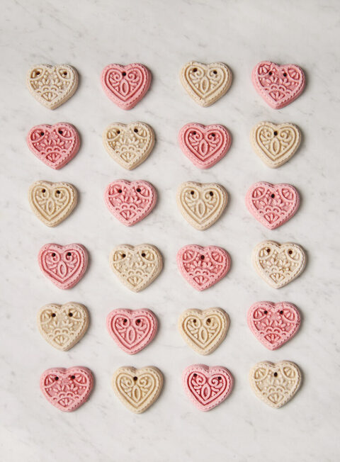 marble board with pink and white hearts laying in rows on it