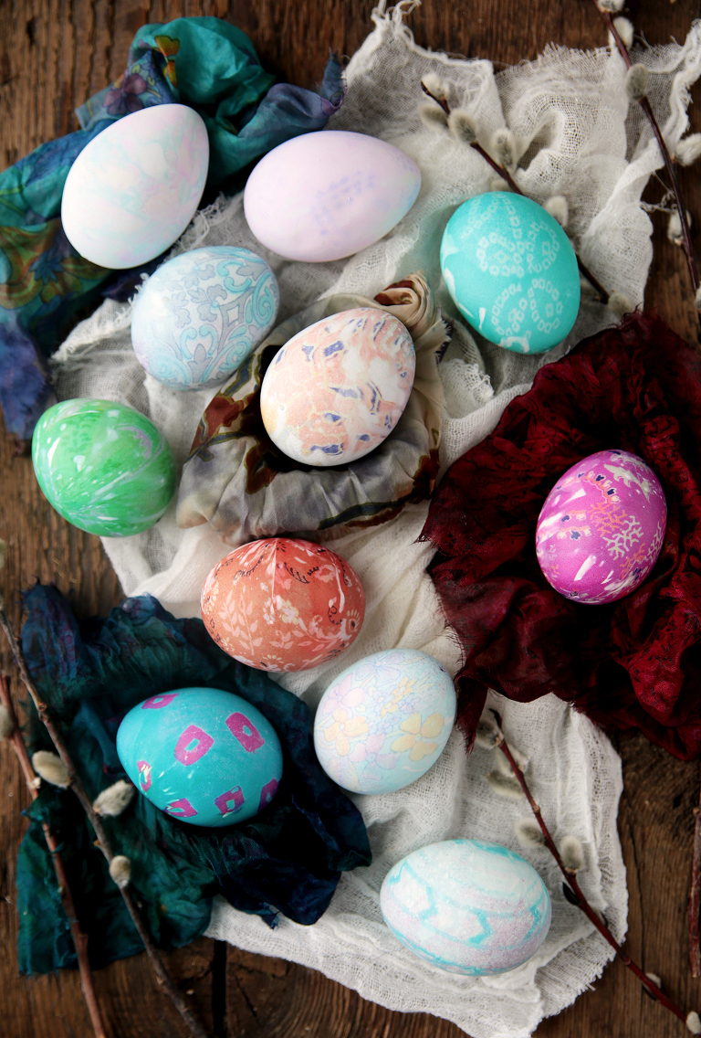 pieces of fabric with silk dyed eggs laying on them with pussy willow branches next to them