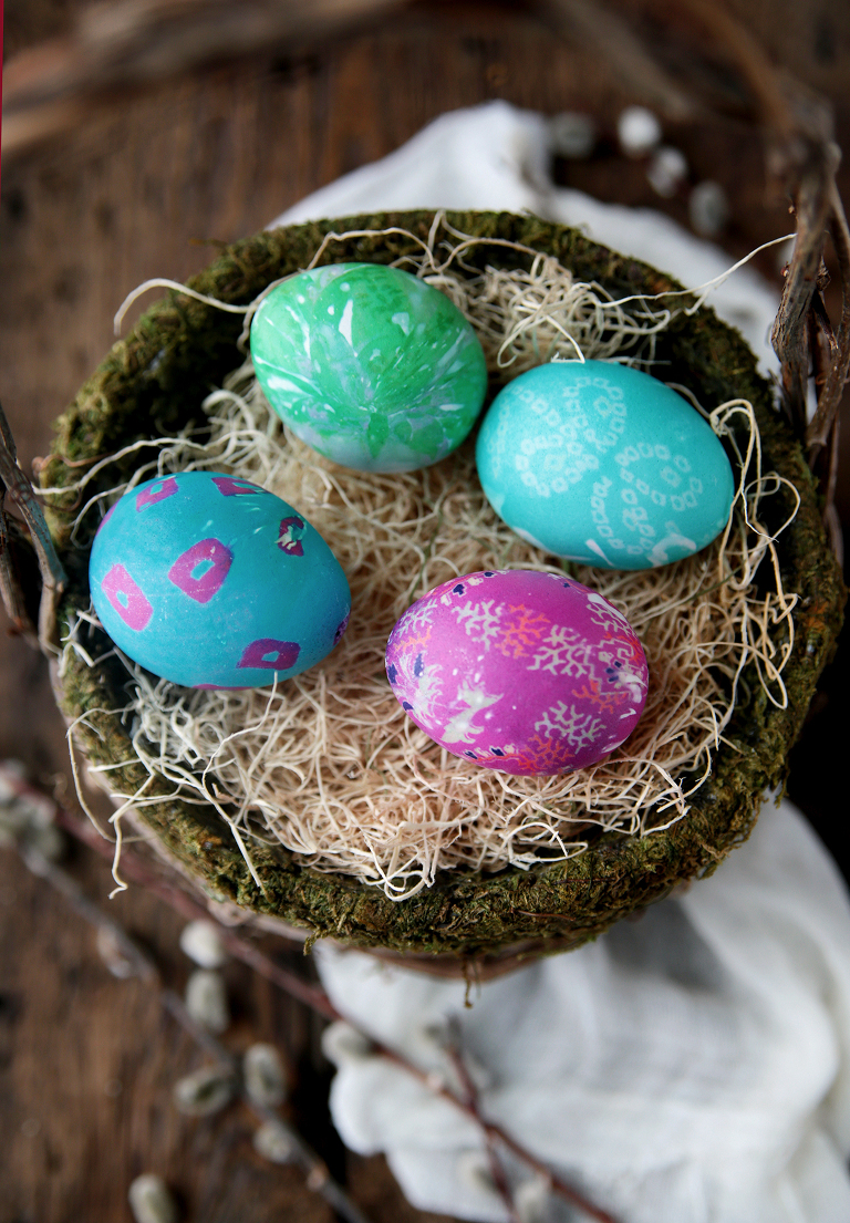 vibrant easter eggs in moss basket