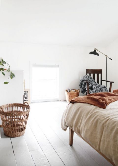 simple white bedroom with rocking chair and black floor lamp