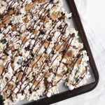 baking sheet with popcorn, golden grahams and chocolate drizzle on it