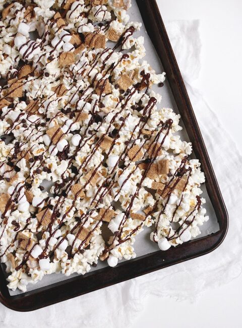 baking sheet with popcorn, golden grahams and chocolate drizzle on it