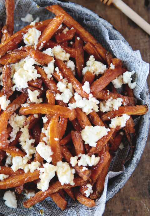 close up pictures of plate of fries with goat cheese and honey on fries