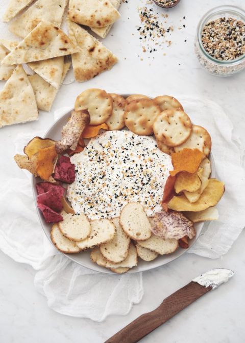 plate of dip surrounded by chips and crackers